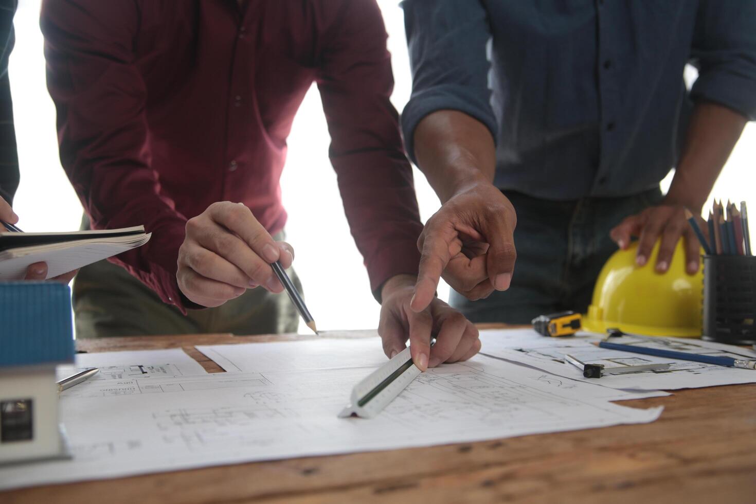 concepto de construcción y estructura de reunión de ingenieros o arquitectos para el proyecto que trabaja con socios y herramientas de ingeniería en la construcción de modelos y planos en el lugar de trabajo, contrato para ambas empresas. foto