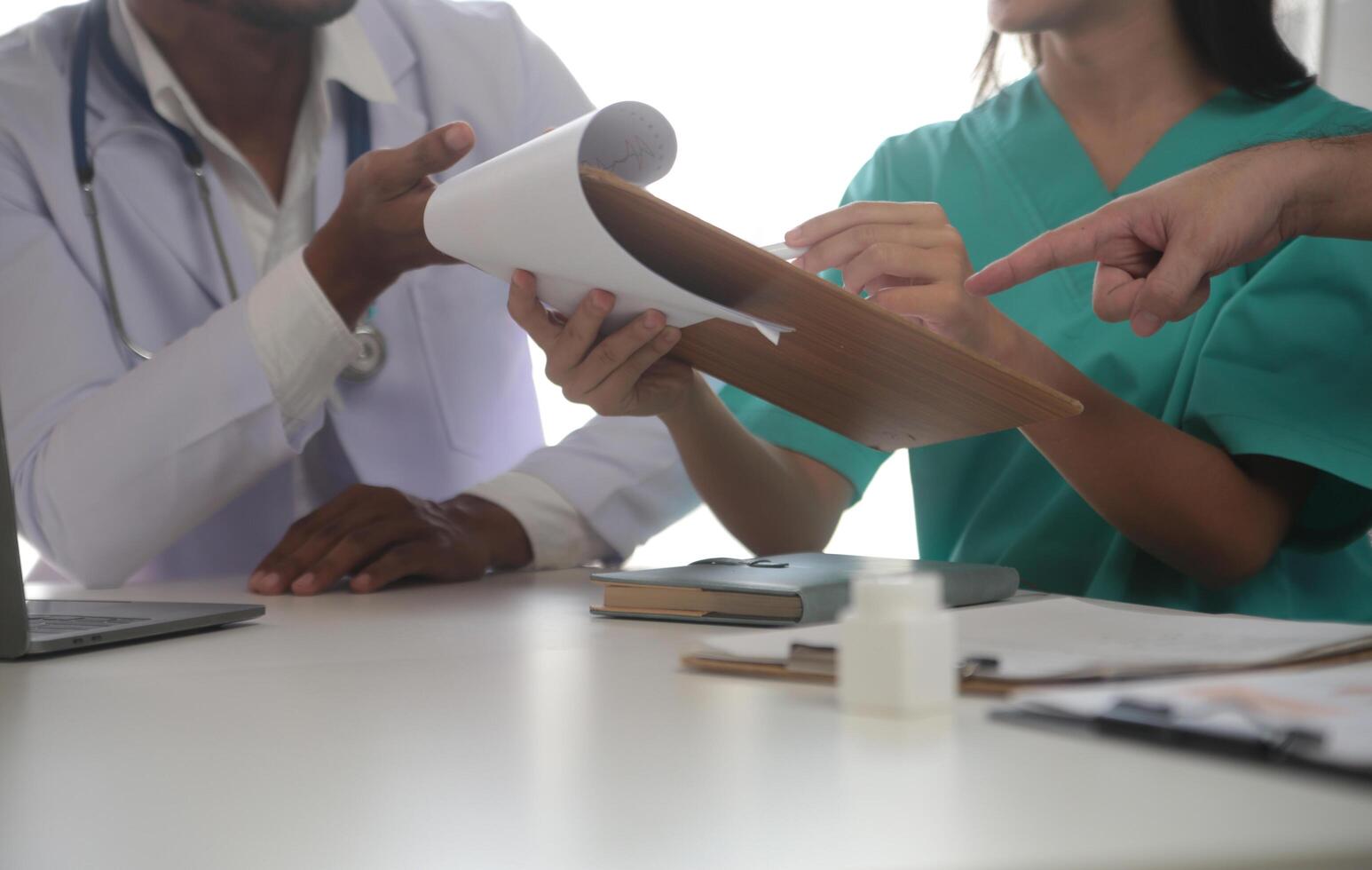 médico equipo reunión alrededor mesa en moderno hospital foto