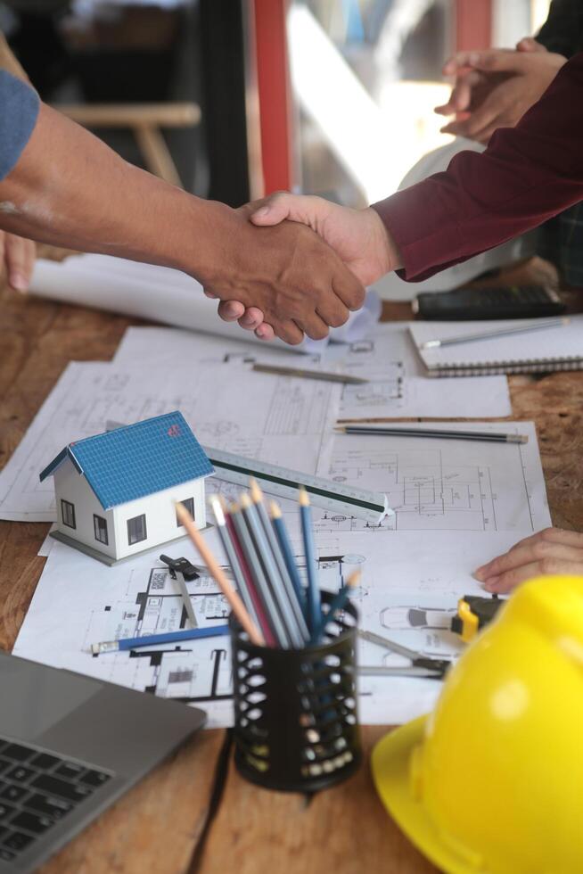 Engineer and contractor join hands after signing contract,They are having a modern building project together. successful cooperation team concept photo