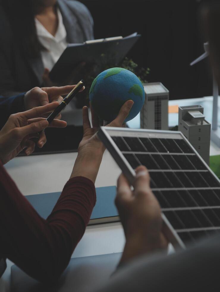 Business people having consultation about wind energy at company office. Business team discussing about windmill and alternative green energy. Executive meeting at modern office photo