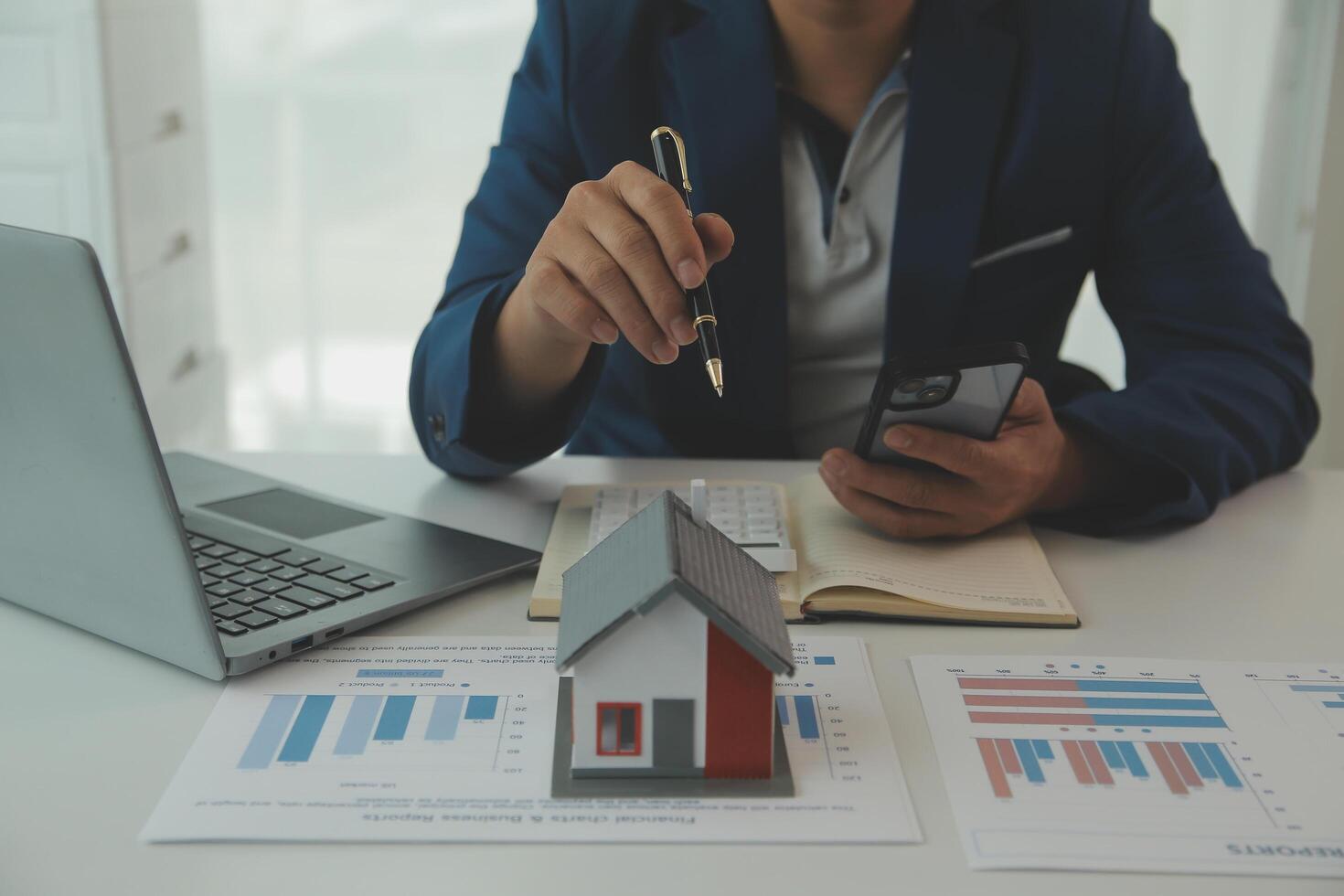 Businessmen holding pens, signing home titles with insurance, care about real estate services and the idea of real estate agents offering interest in installments to their customers. photo
