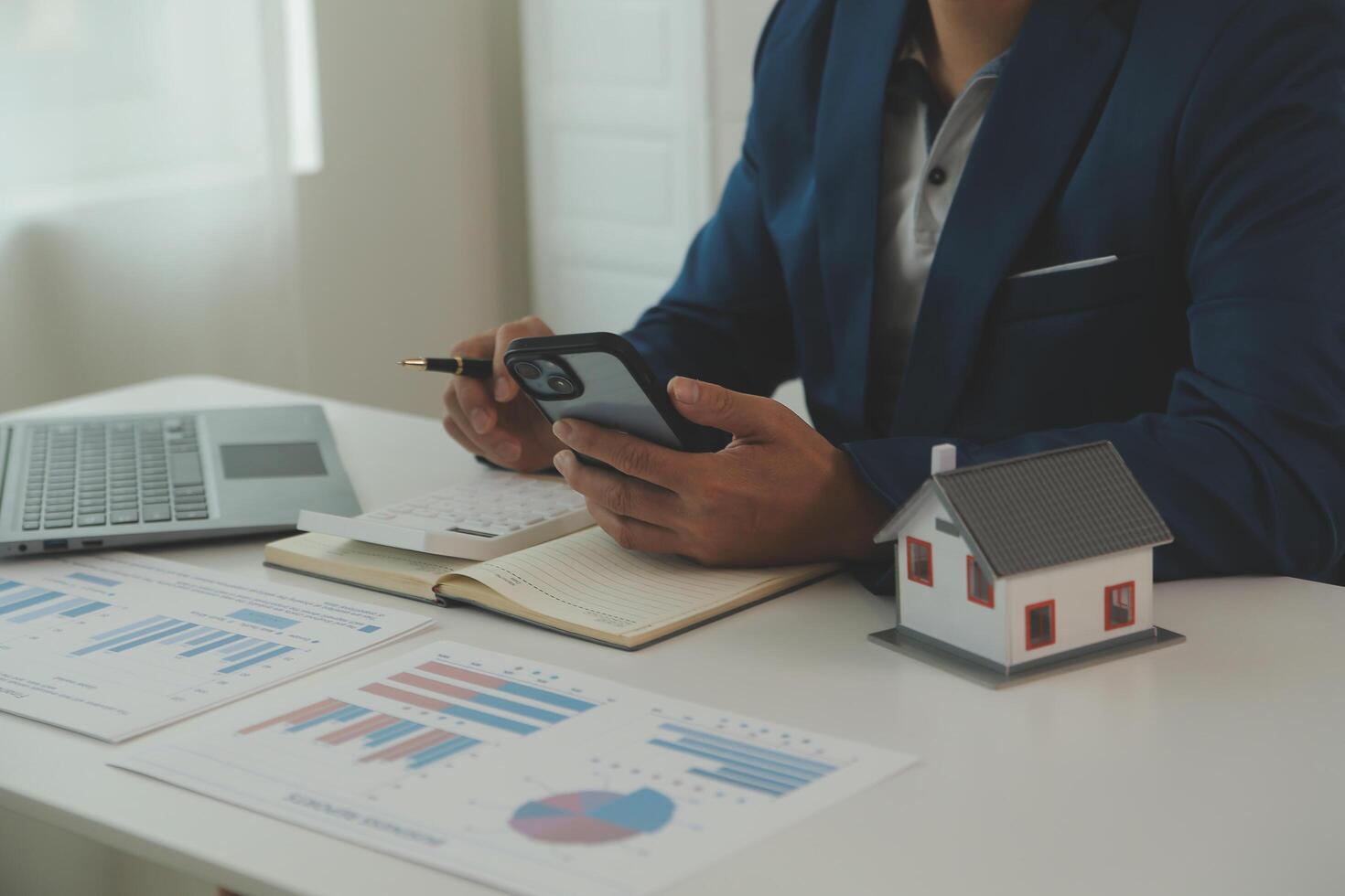 Businessmen holding pens, signing home titles with insurance, care about real estate services and the idea of real estate agents offering interest in installments to their customers. photo