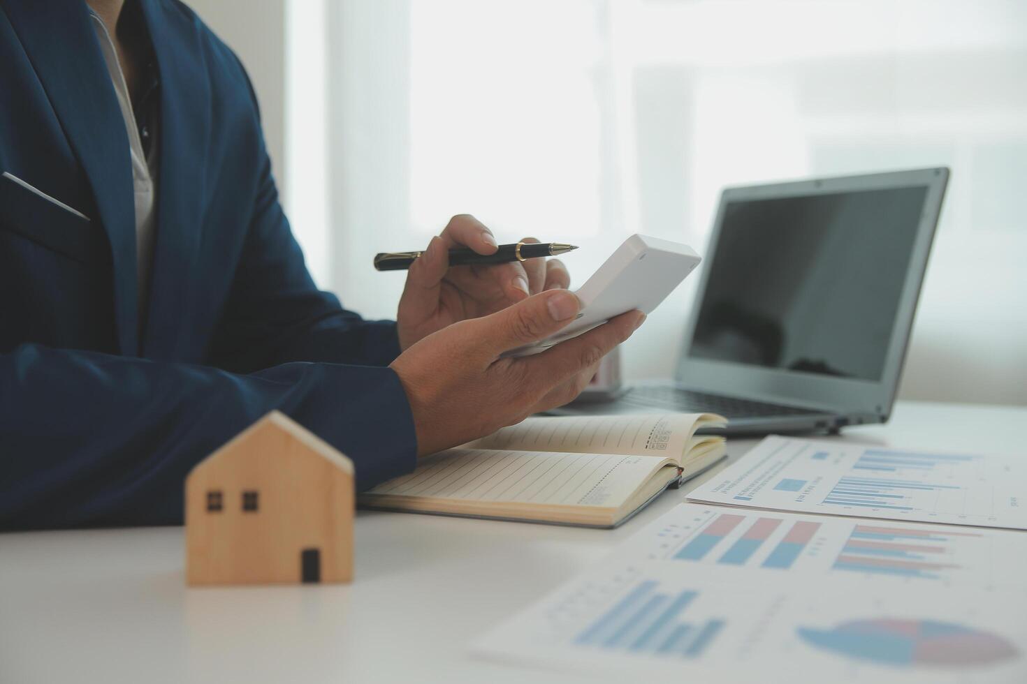 Businessmen holding pens, signing home titles with insurance, care about real estate services and the idea of real estate agents offering interest in installments to their customers. photo