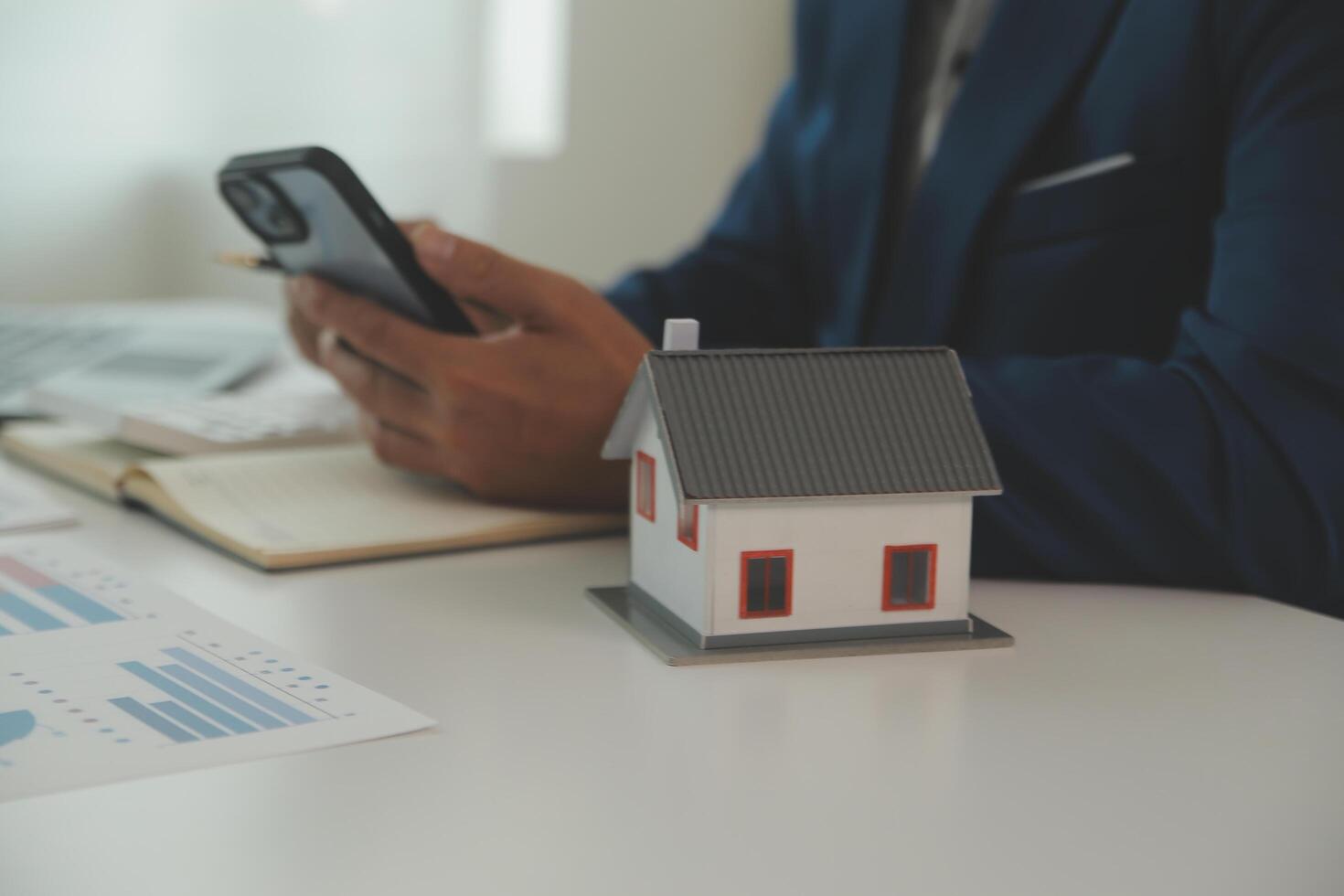 Businessmen holding pens, signing home titles with insurance, care about real estate services and the idea of real estate agents offering interest in installments to their customers. photo