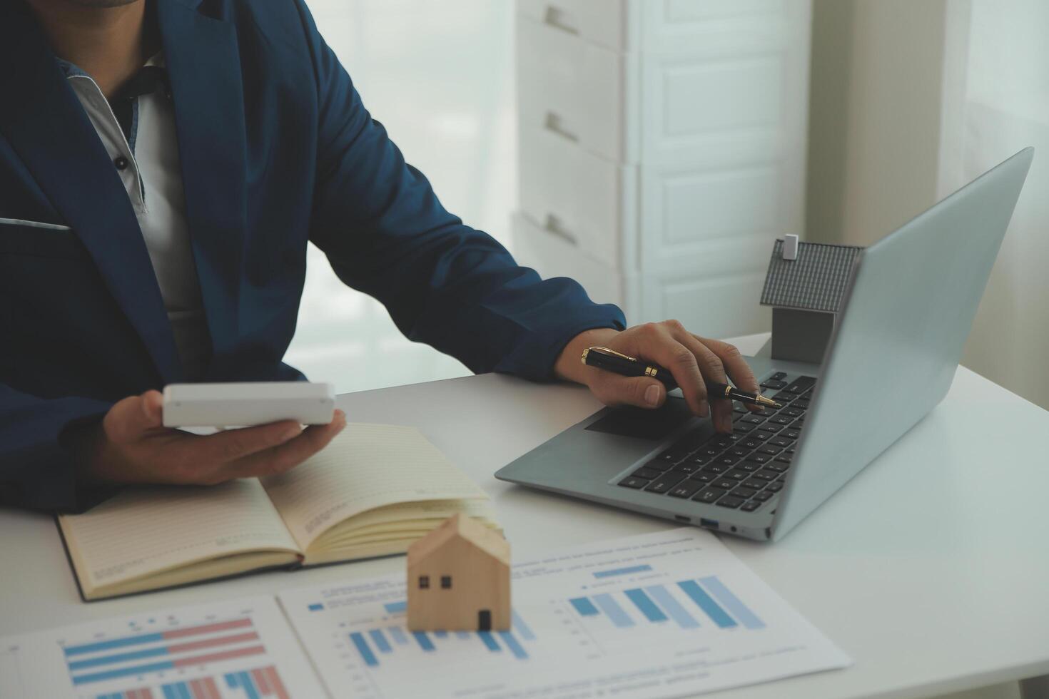 Businessmen holding pens, signing home titles with insurance, care about real estate services and the idea of real estate agents offering interest in installments to their customers. photo
