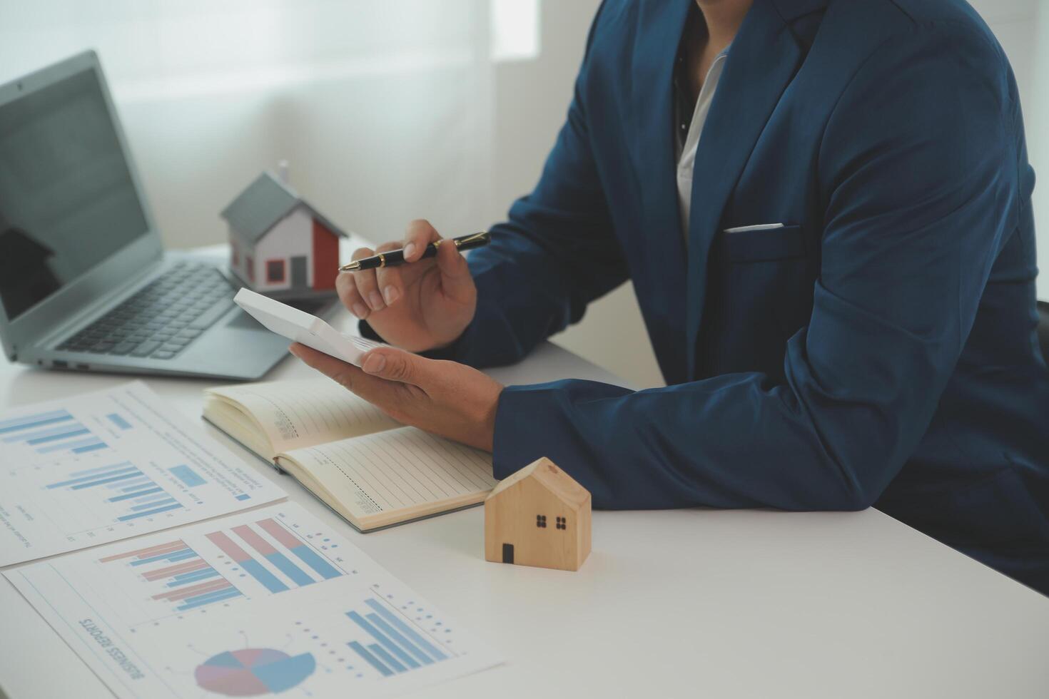 Businessmen holding pens, signing home titles with insurance, care about real estate services and the idea of real estate agents offering interest in installments to their customers. photo