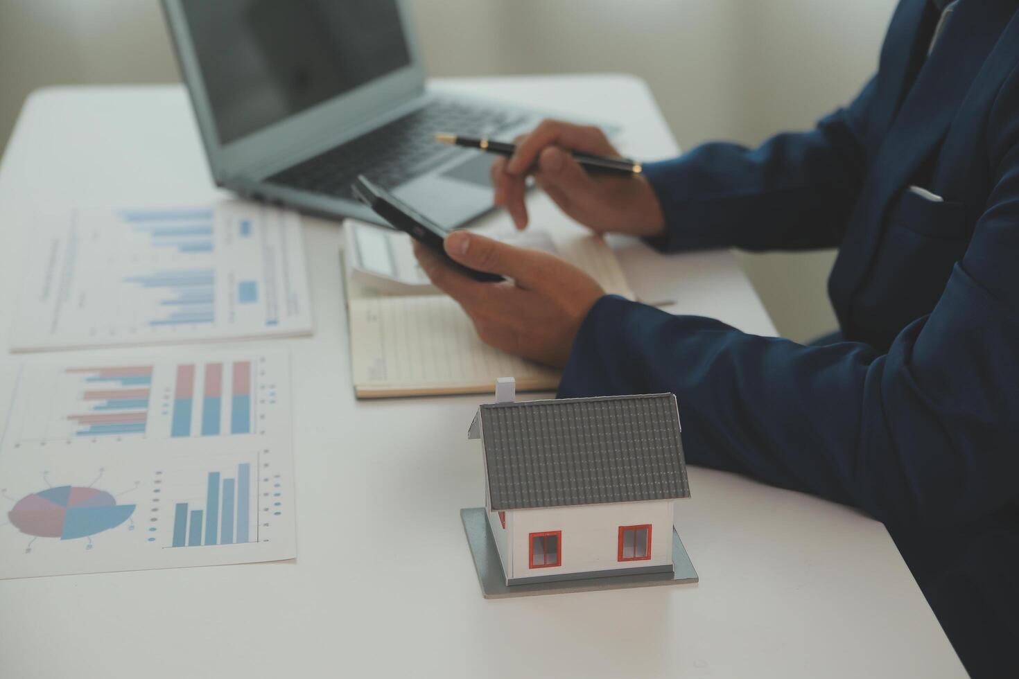 Businessmen holding pens, signing home titles with insurance, care about real estate services and the idea of real estate agents offering interest in installments to their customers. photo
