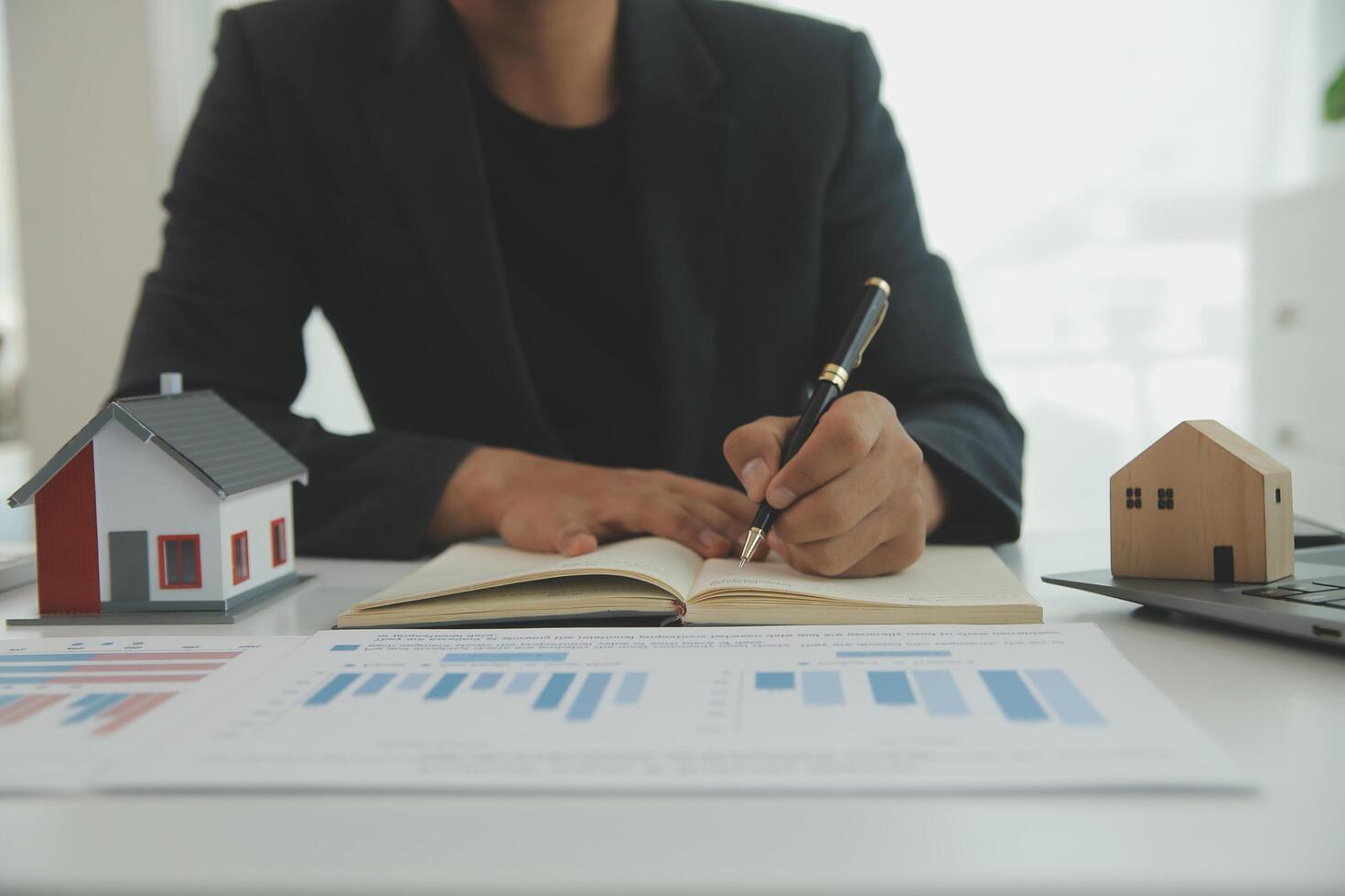 Businessmen holding pens, signing home titles with insurance, care about real estate services and the idea of real estate agents offering interest in installments to their customers. photo