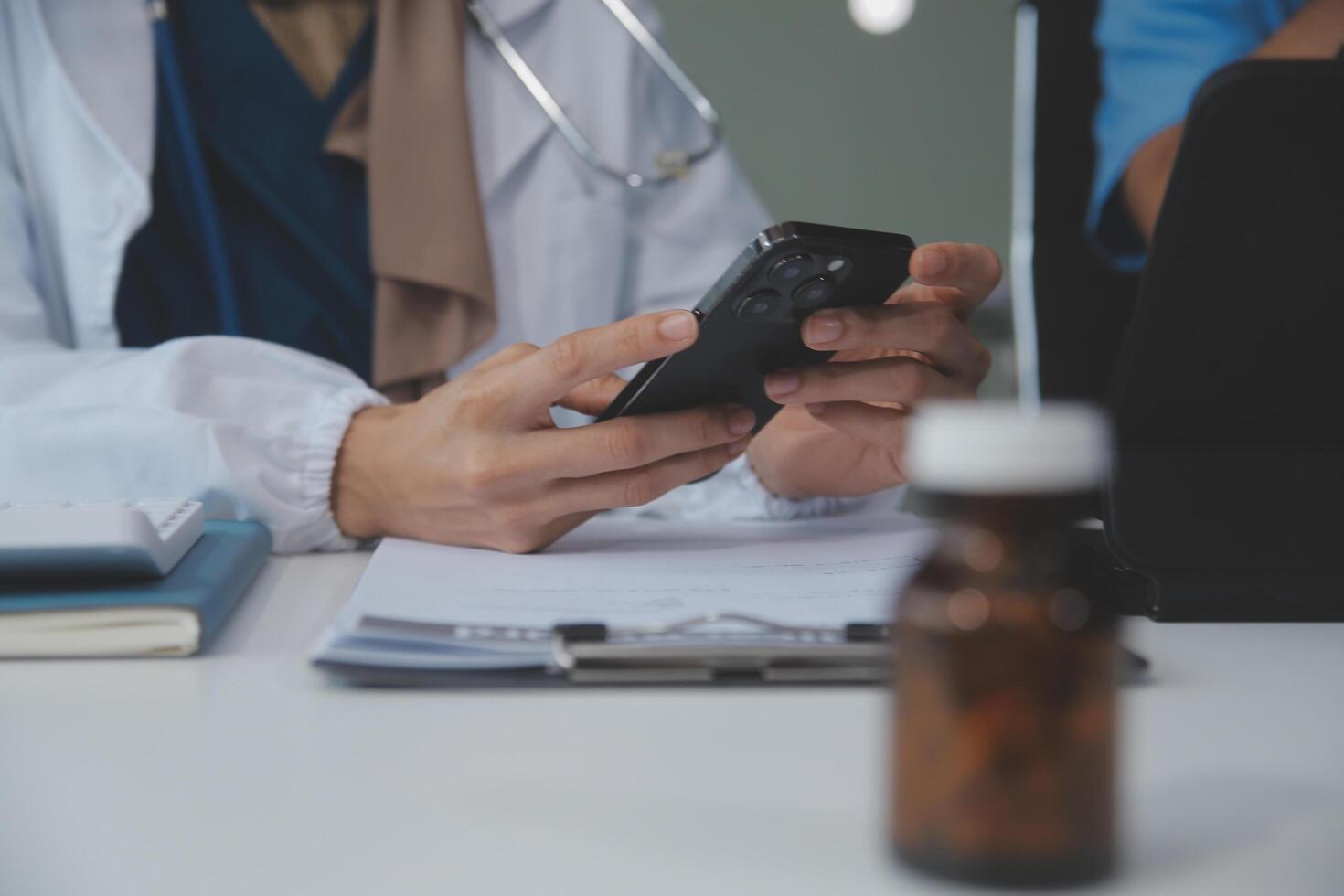 asiático psicólogo mujer señalando en pastillas botella a explicando medicina y prescripción a hembra paciente mientras dando asesoramiento acerca de médico y mental salud terapia a hembra paciente en clínica. foto