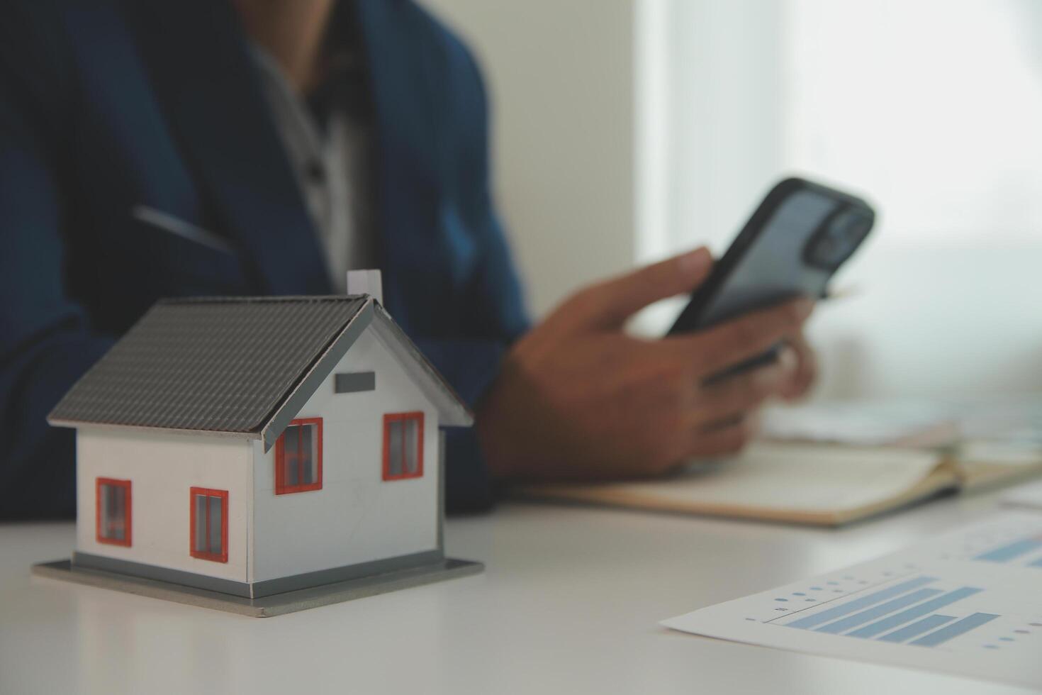 Businessmen holding pens, signing home titles with insurance, care about real estate services and the idea of real estate agents offering interest in installments to their customers. photo