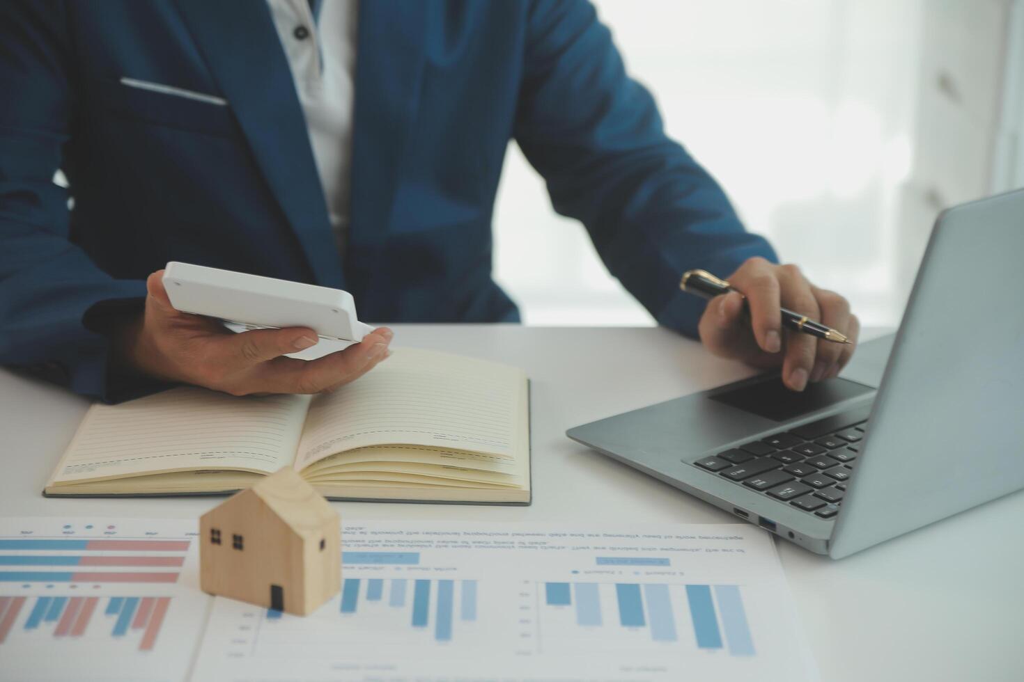 Businessmen holding pens, signing home titles with insurance, care about real estate services and the idea of real estate agents offering interest in installments to their customers. photo