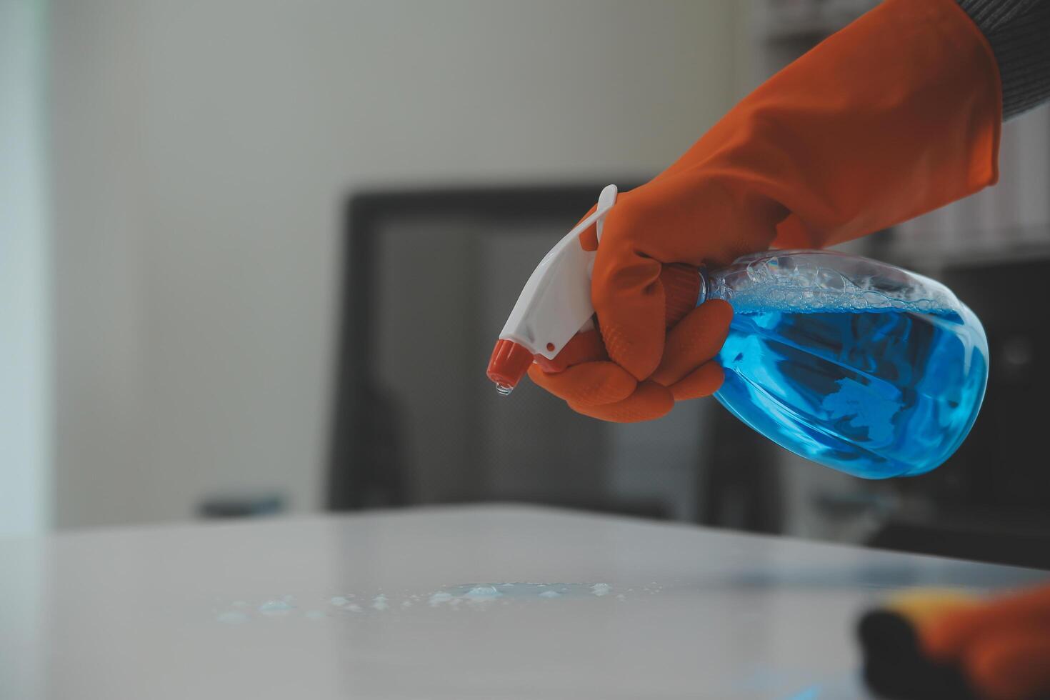 Woman cleaning table using rag and diffuser at home. photo