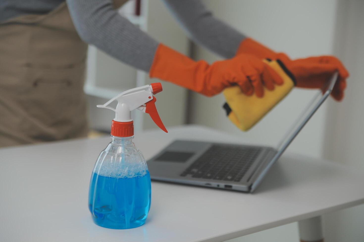 Woman cleaning table using rag and diffuser at home. photo