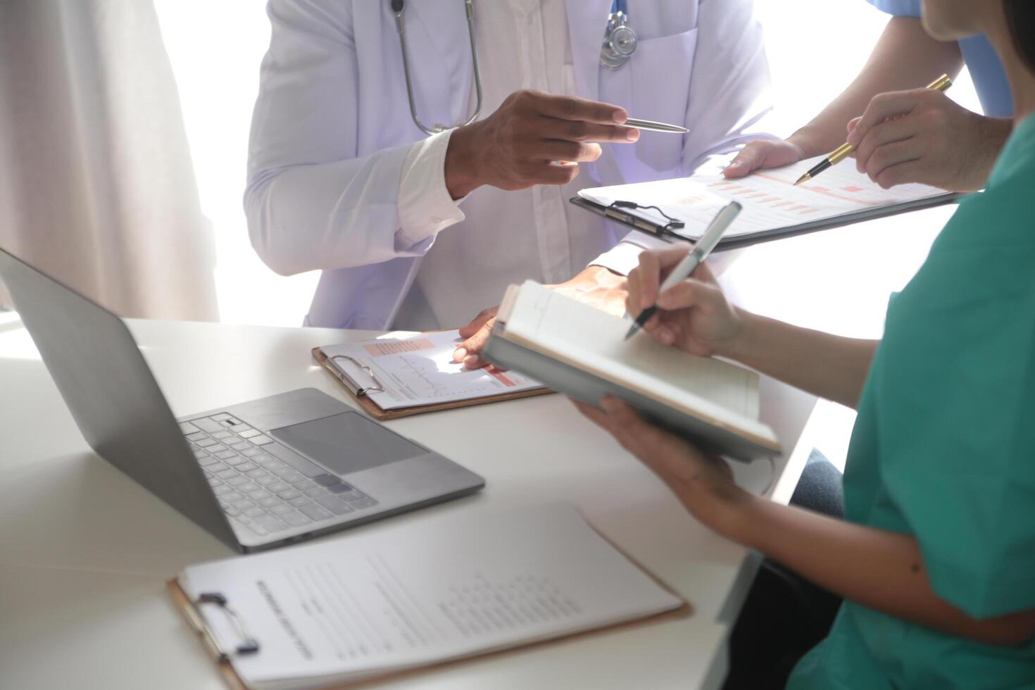 médico equipo reunión alrededor mesa en moderno hospital foto