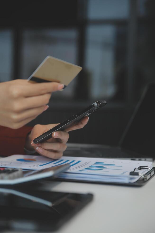 mano participación crédito tarjeta y utilizando ordenador portátil. mujer de negocios o empresario trabajando desde hogar. en línea compras, comercio electrónico, Internet bancario, gasto dinero, trabajo desde hogar concepto foto