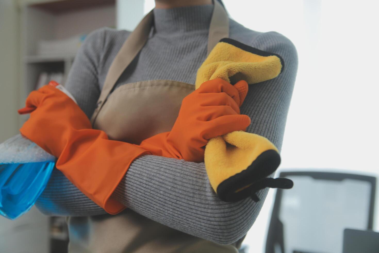 Woman cleaning table using rag and diffuser at home. photo