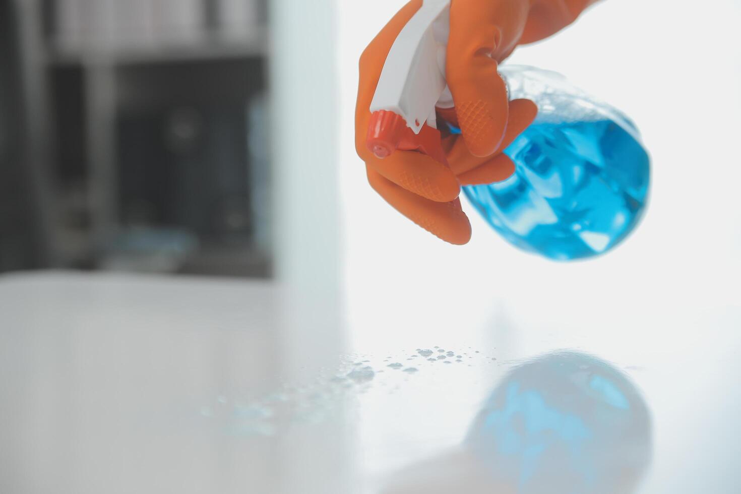 Woman cleaning table using rag and diffuser at home. photo