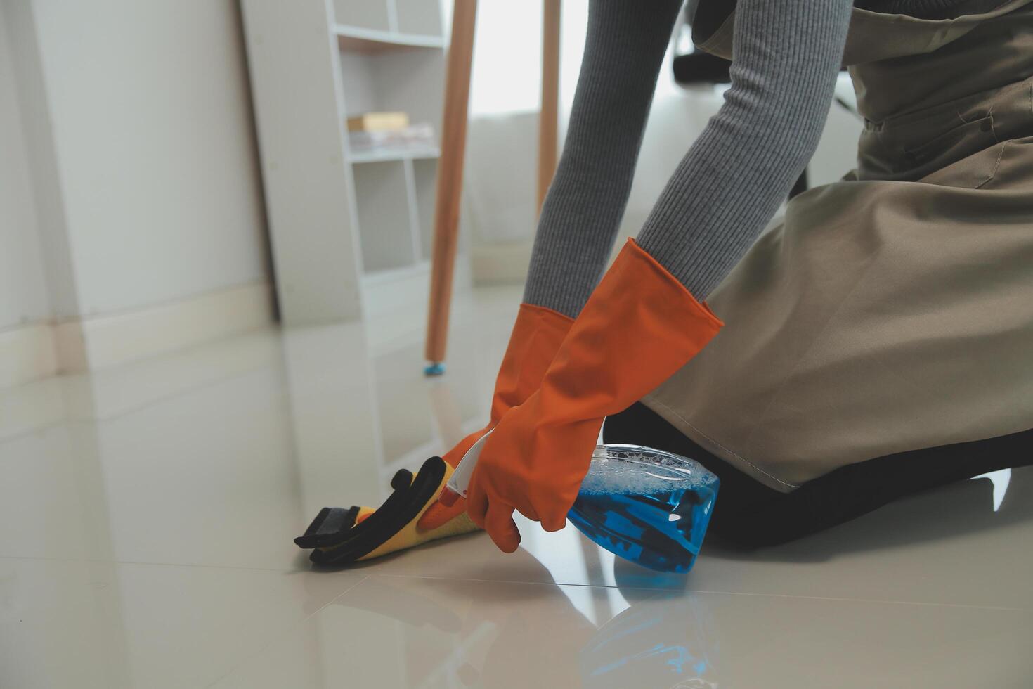 Woman cleaning table using rag and diffuser at home. photo