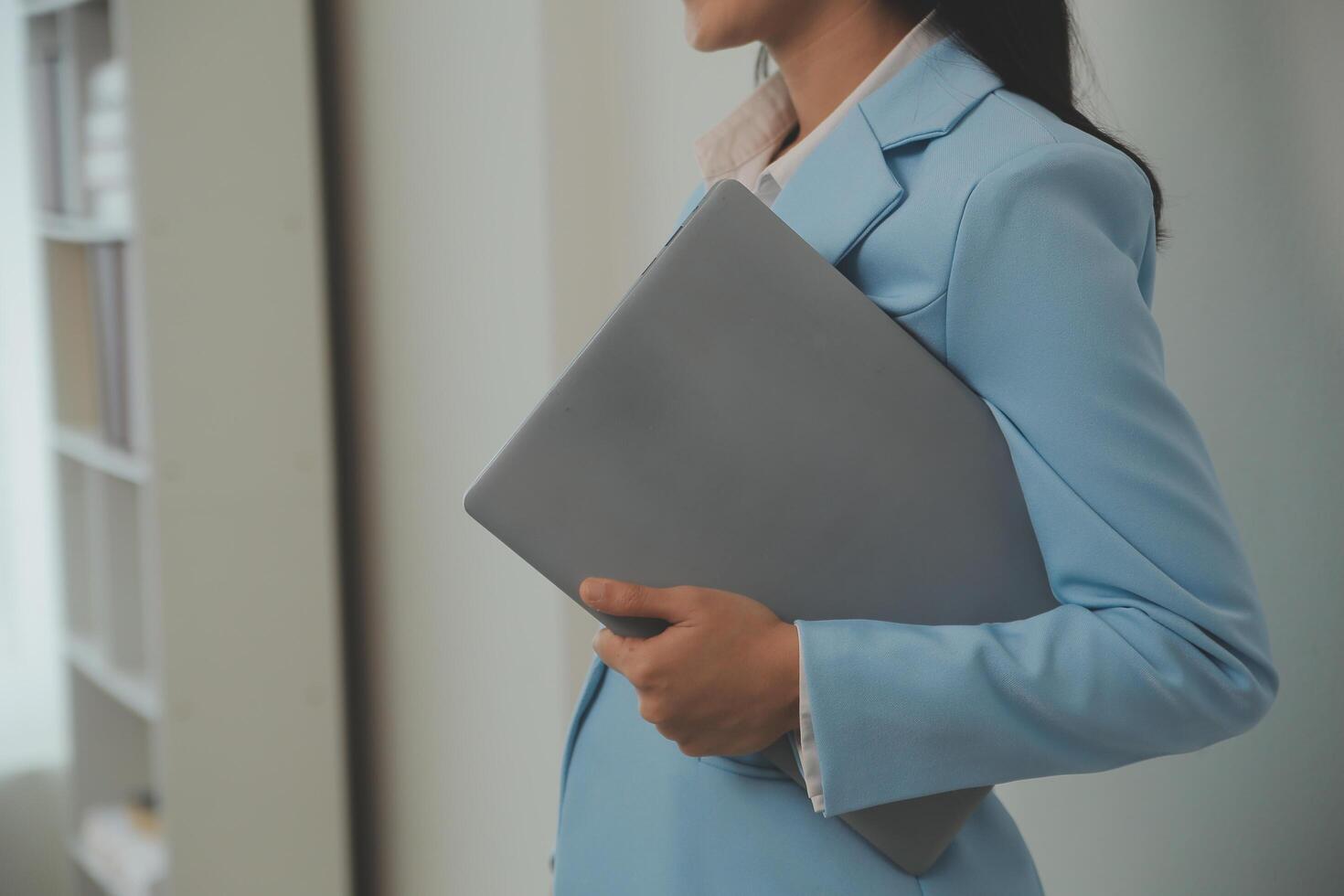 Portrait of a happy asian businesswoman working on laptop computer isolated over white background photo