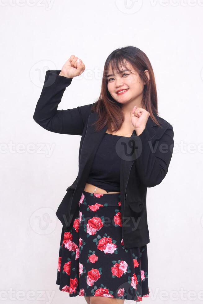 Beautiful Asian Indonesian girl in a casual professional office skirt, happy, hands clenched upwards, happy on a white background for promotion, advertising, banner photo
