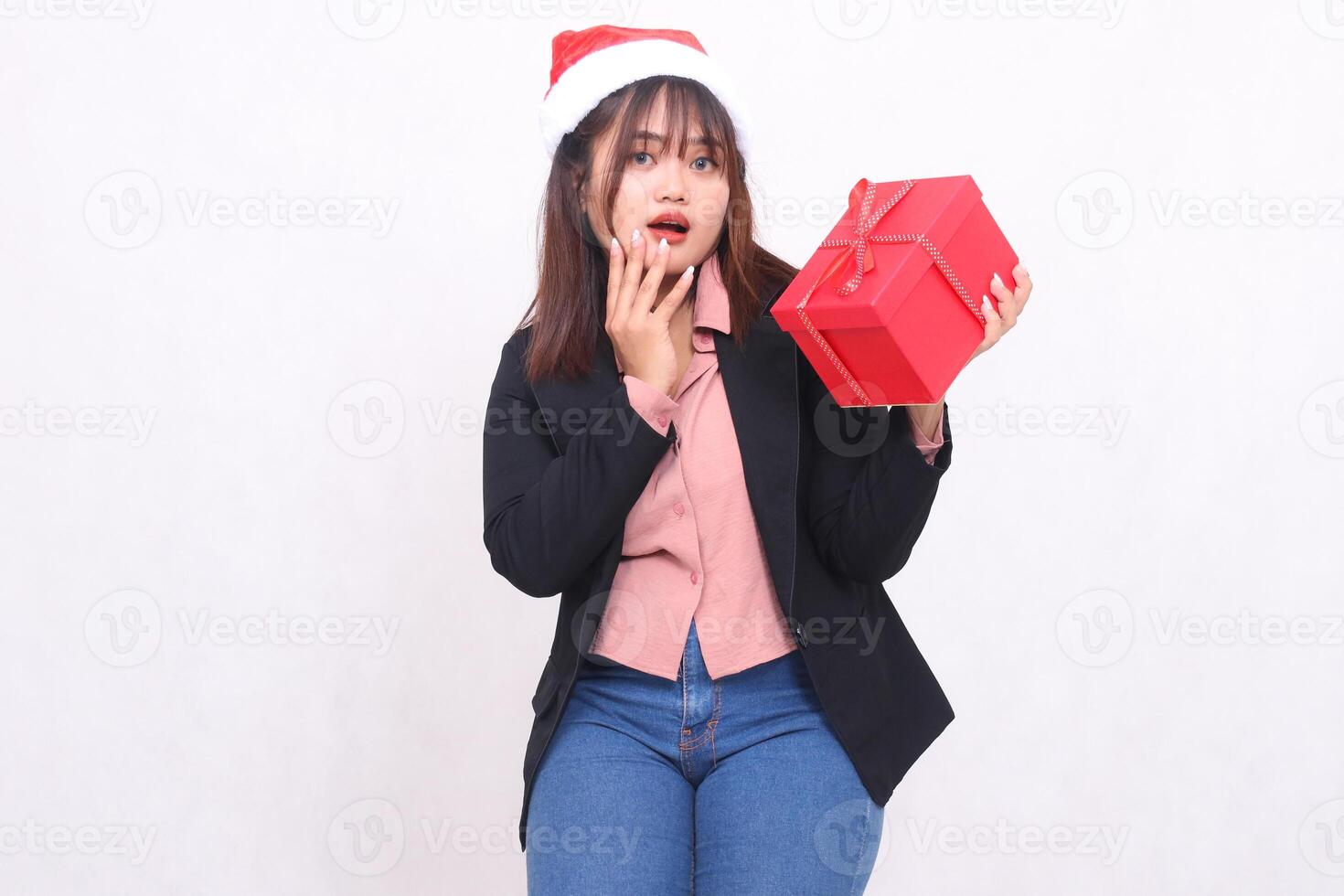 Beautiful asian girl in shocked suit with Santa Claus hat posing with Christmas gift box gifts and lifting announcement box on white background for promotion, advertising, banner, billboard photo