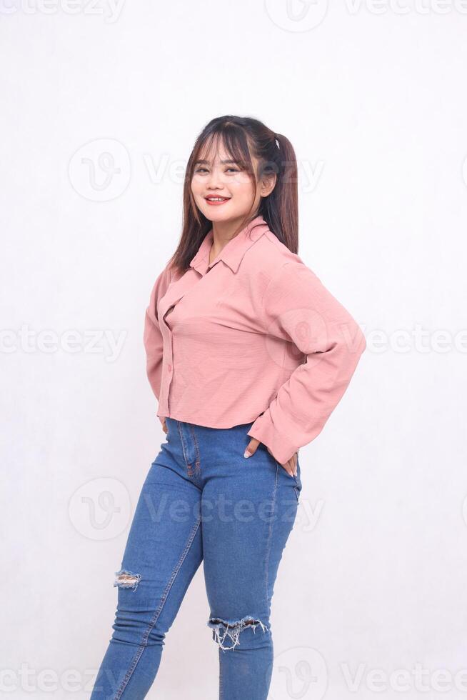 Young beautiful cool Asian woman hands holding on hips and looking at the camera with smile face and stylish beautiful girl like working, used advertising on white background photo