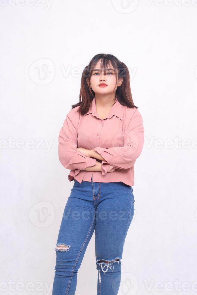 Cool beautiful young Asian woman with her arms crossed to the right and looking at the camera with an angry face and beautiful girl looking like she is working, used advertising on a white background photo