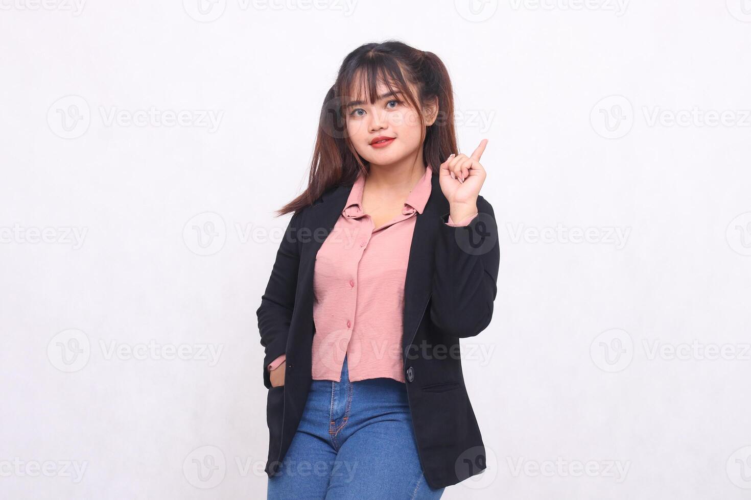 Beautiful Asian businesswoman in suit standing confidently pointing hand up on white background studio portrait for advertising materials, banners, billboards, job vacancies, business opportunities photo