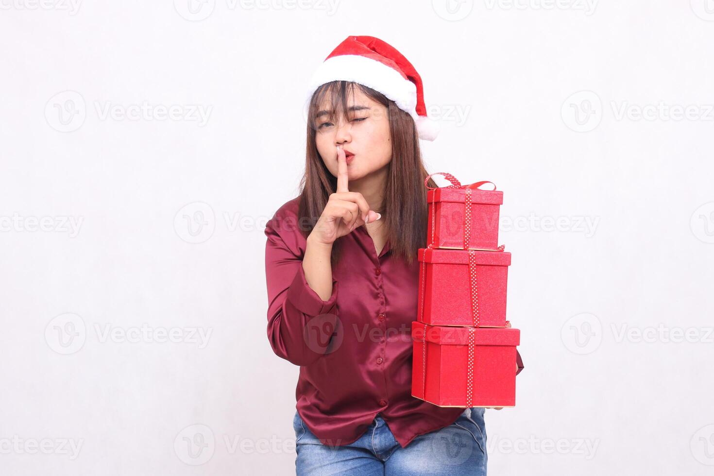 beautiful young southeast asian girl happy broad carrying gifts 3 boxes in christmas wear santa claus hat clothes red shirt modern sign kissing all white background for promotion and advertising photo
