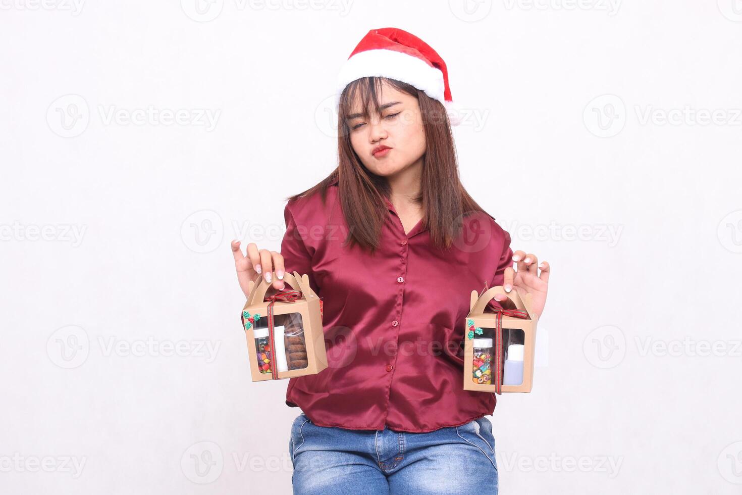 Beautiful young Southeast Asian woman sleeping carrying 2 boxes of hamper gifts at Christmas wearing Santa Claus hat modern red shirt outfit white background for promotion and advertising photo