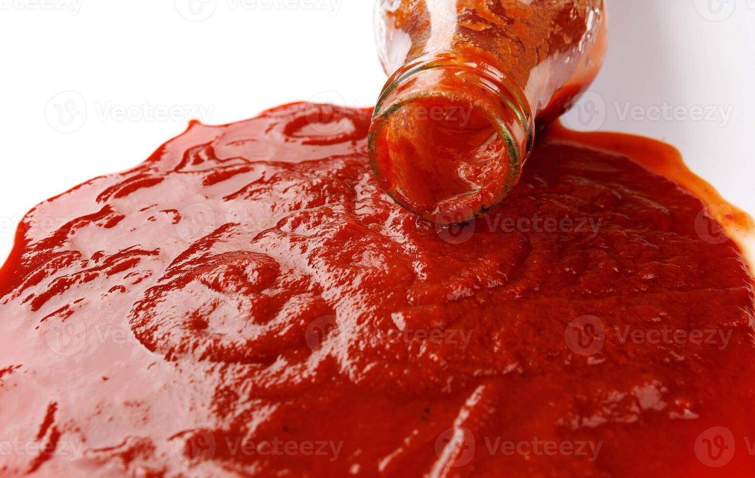 Tomato sauce . Glass bottle with ketchup. Ketchup is pouring out of the neck of a glass bottle. photo