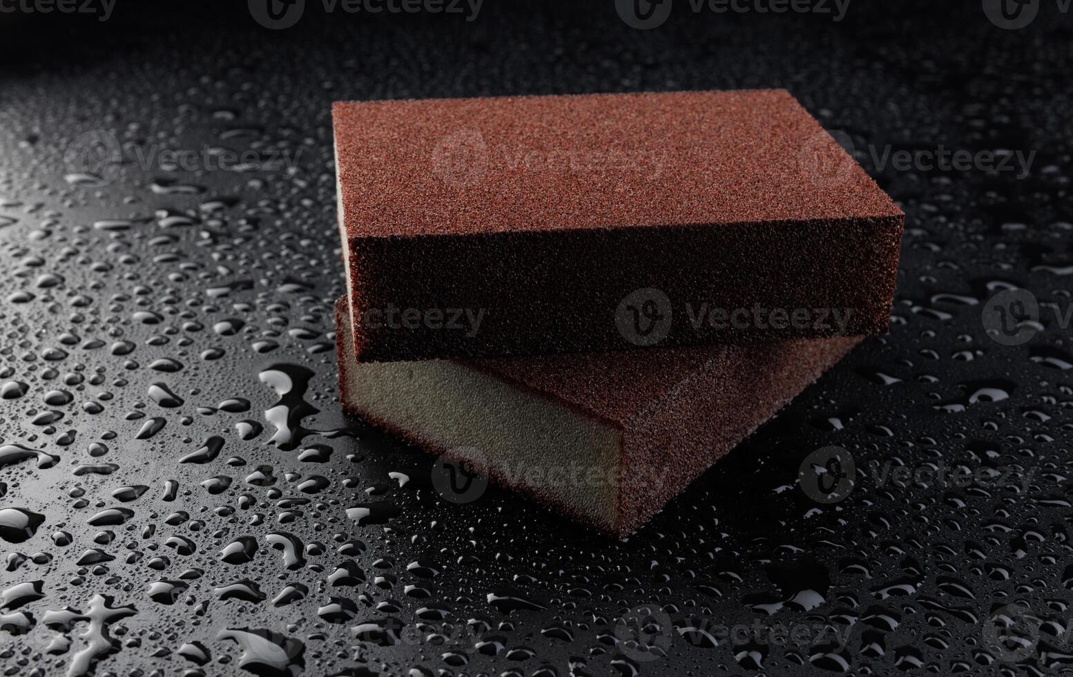 Melamine sponge on a black wet background. Beautiful drops of water around a melamine sponge. photo