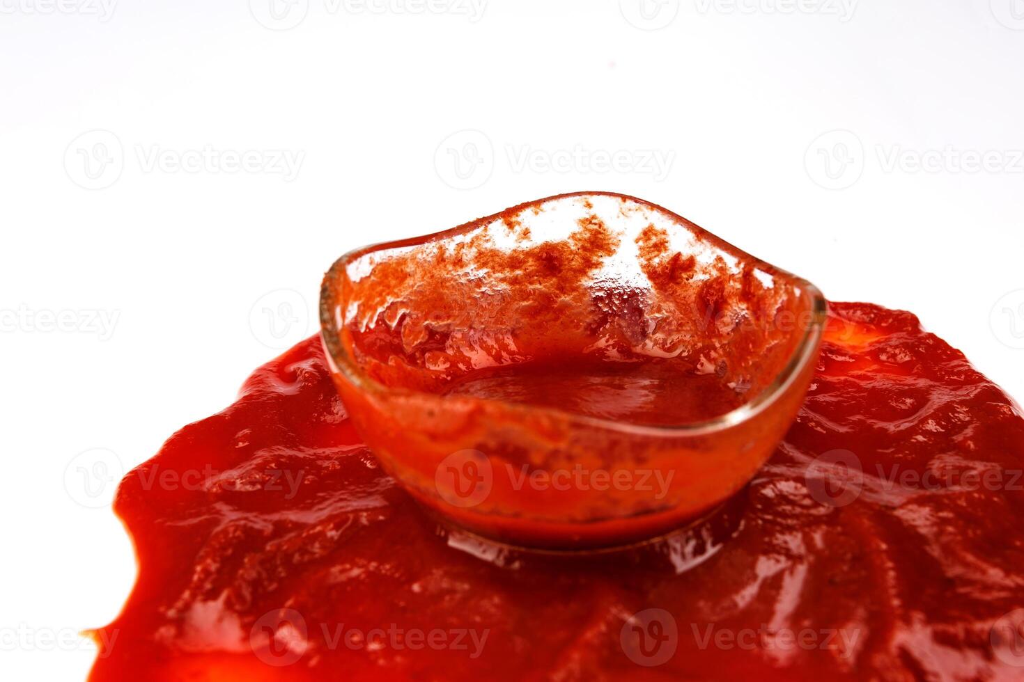 Tomato sauce . Glass cup with remaining ketchup and ketchup spilled around it. photo