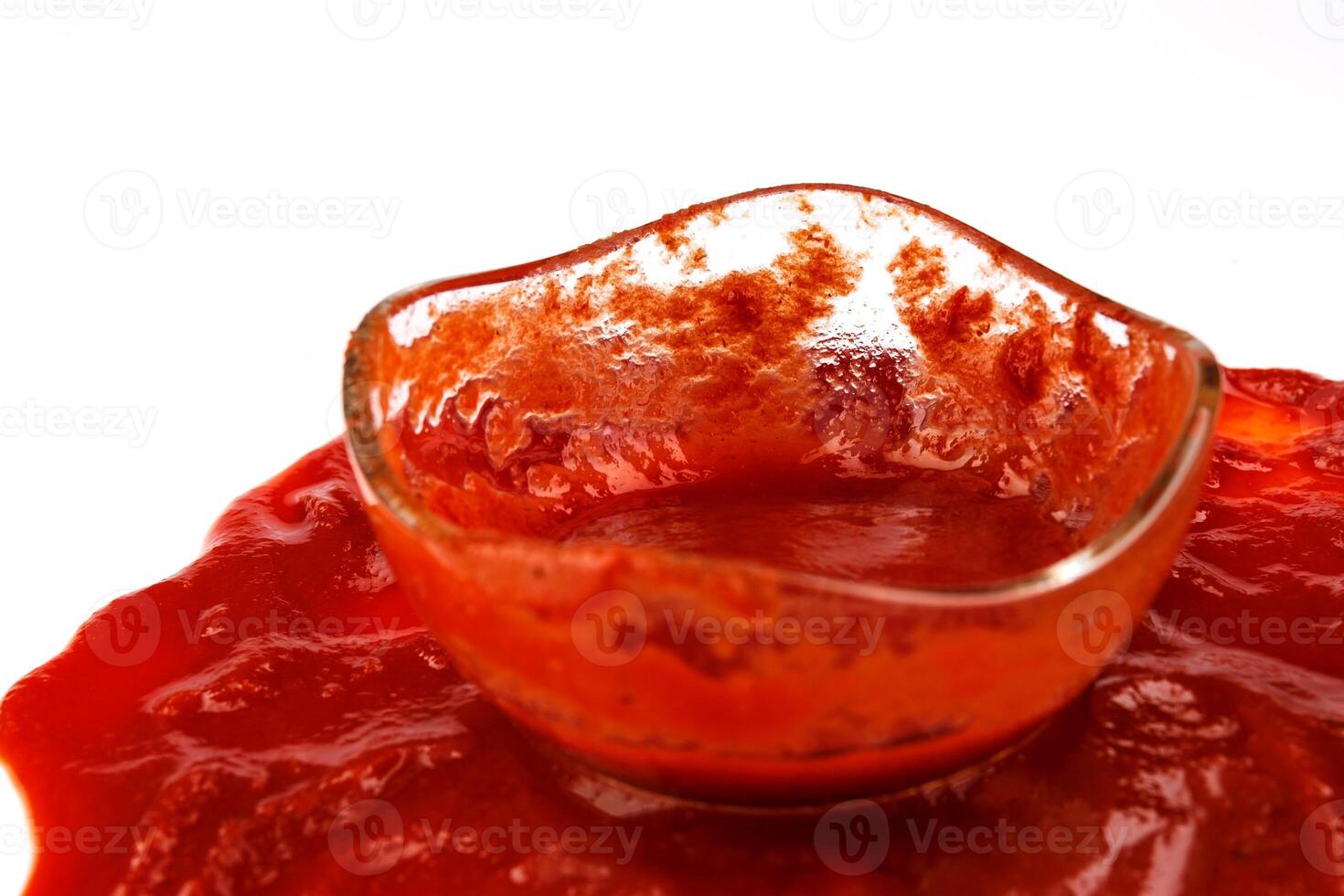 Tomato sauce . Glass cup with remaining ketchup and ketchup spilled around it. photo