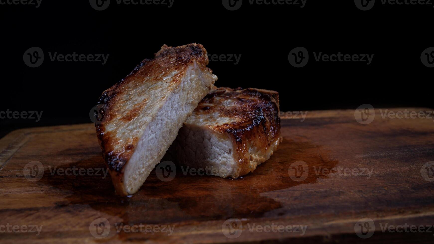 Roasted pork entrecote cut into pieces on a wooden cutting board. Grilled pork entrecote. Pork steak. photo