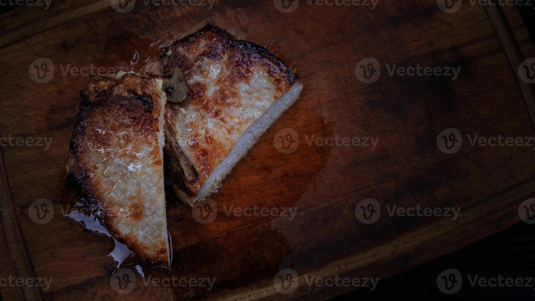 Roasted pork entrecote cut into pieces on a wooden cutting board. Grilled pork entrecote. Pork steak. photo