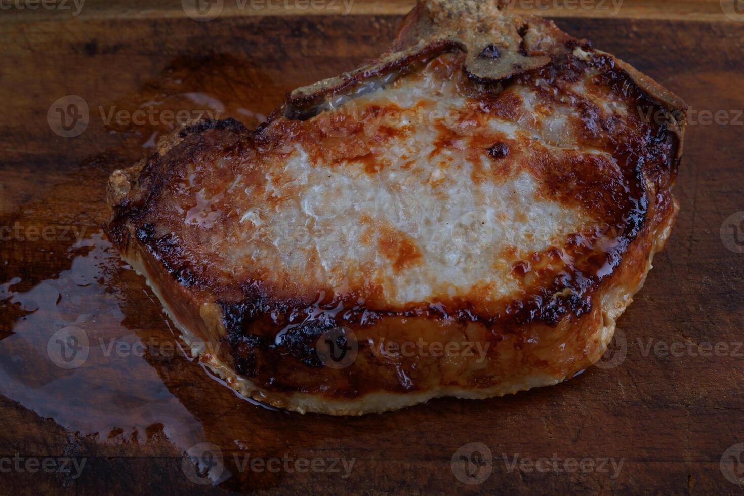 Roasted pork entrecote on a wooden cutting board. Grilled pork entrecote. Pork steak. photo