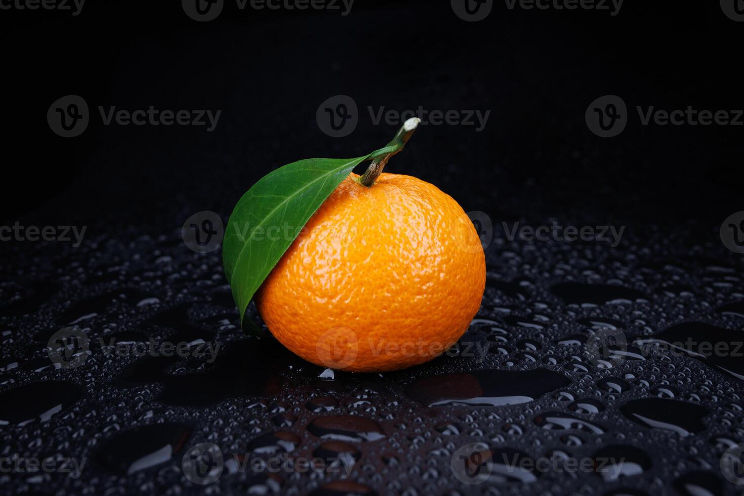 maduro jugoso Mandarina en un negro antecedentes con agua gotas. foto