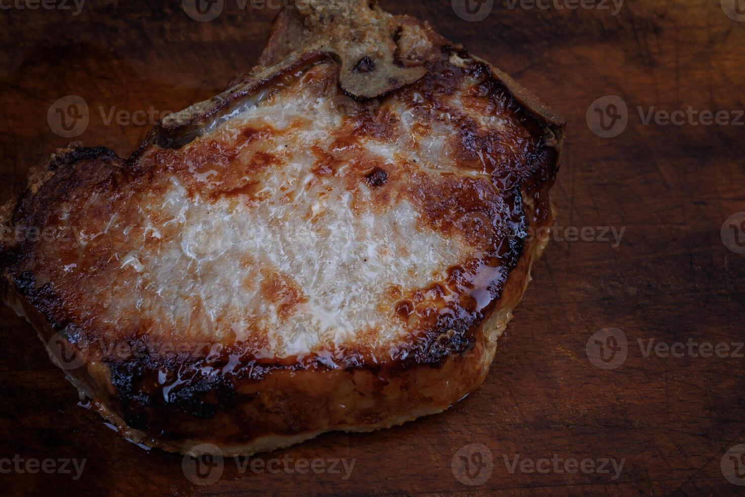 Roasted pork entrecote on a wooden cutting board. Grilled pork entrecote. Pork steak. photo