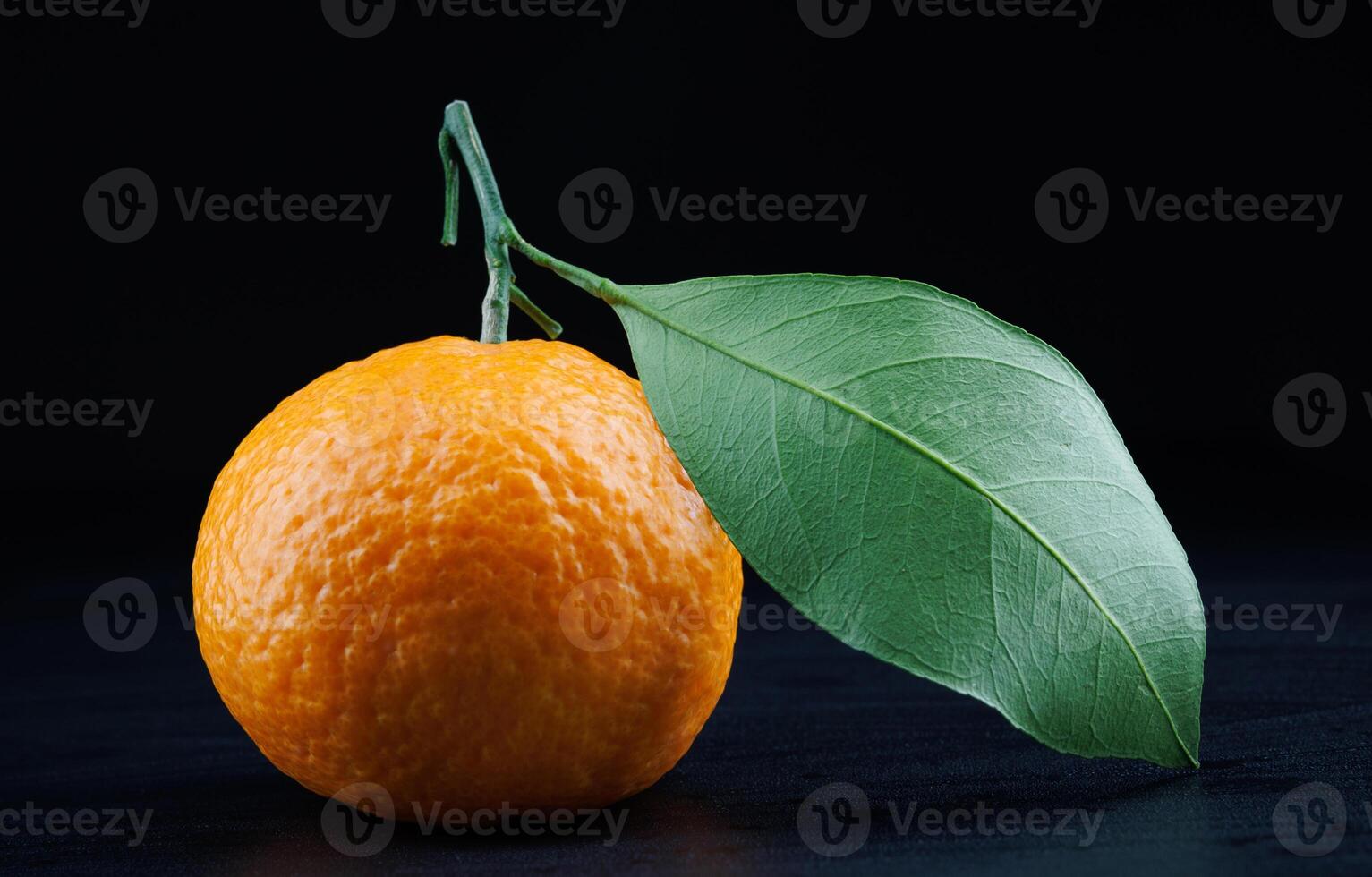 Ripe juicy tangerine on a dark background. photo