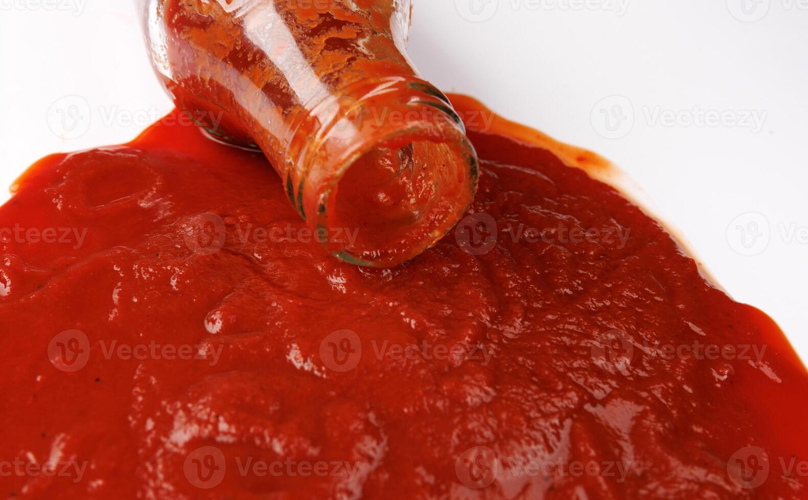 Tomato sauce . Glass bottle with ketchup. Ketchup is pouring out of the neck of a glass bottle. photo