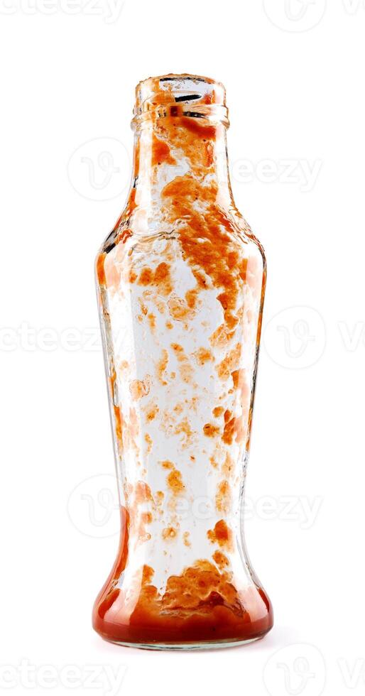 Tomato sauce . Empty ketchup bottle. Glass bottle with ketchup remains isolated on a white background. photo
