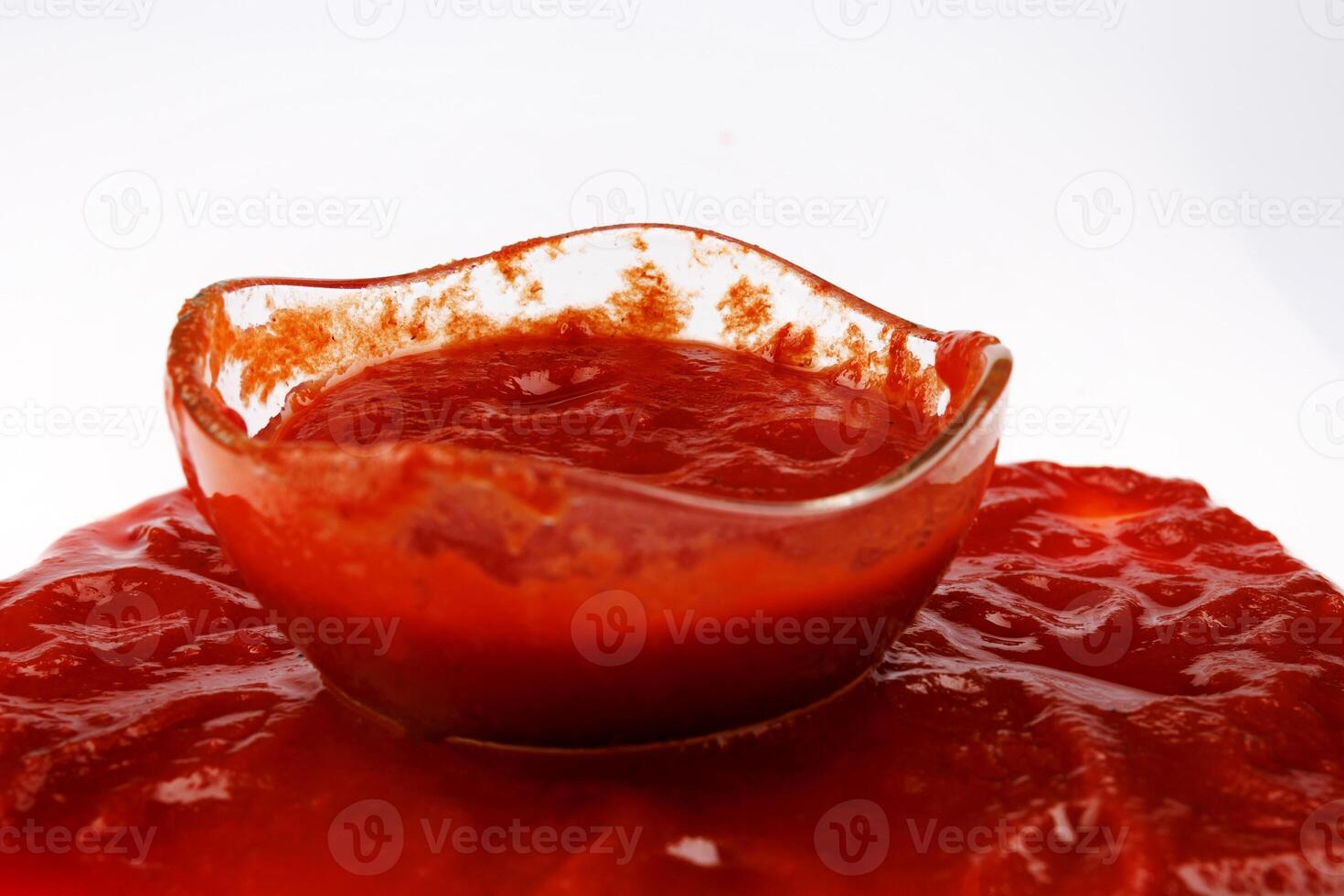 Tomato sauce . Glass cup with remaining ketchup and ketchup spilled around it. photo