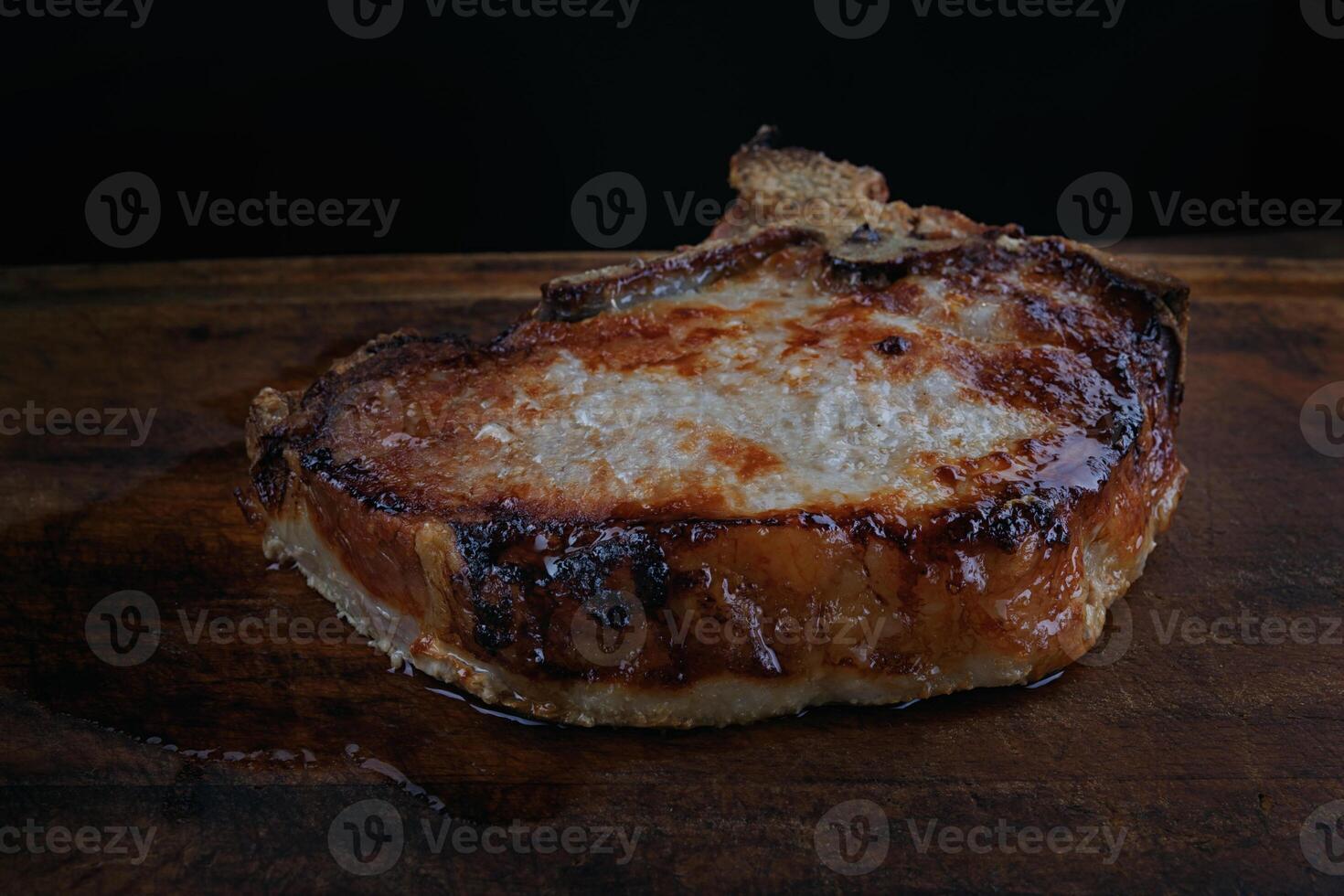 Roasted pork entrecote on a wooden cutting board. Grilled pork entrecote. Pork steak. photo