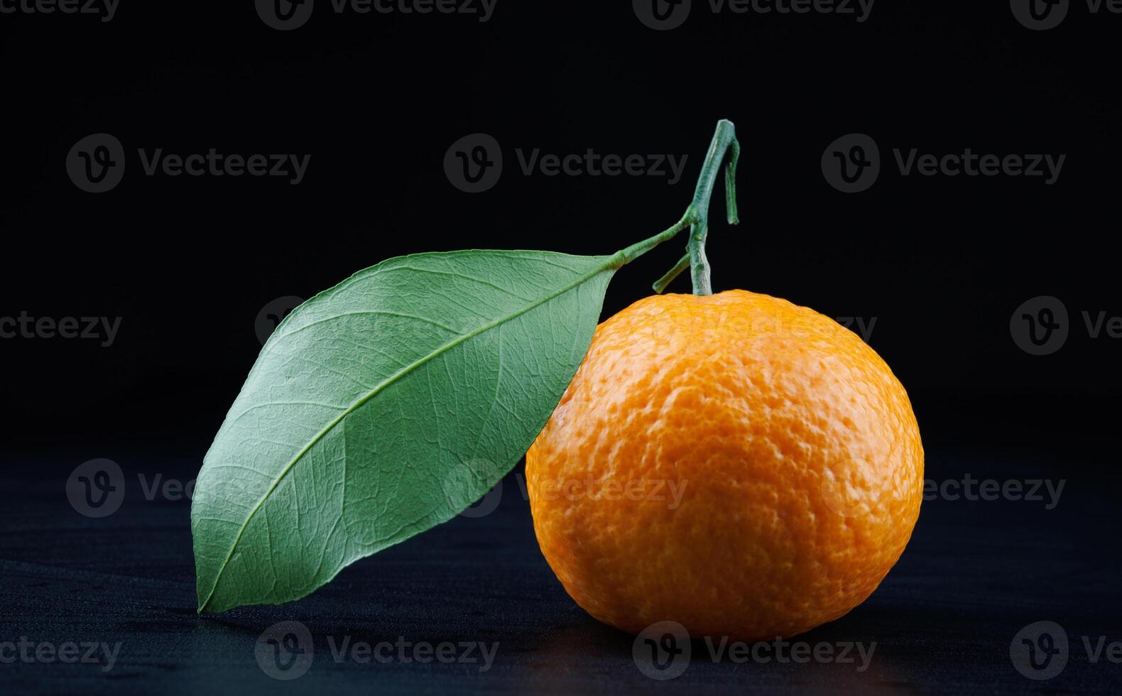 Ripe juicy tangerine on a dark background. photo