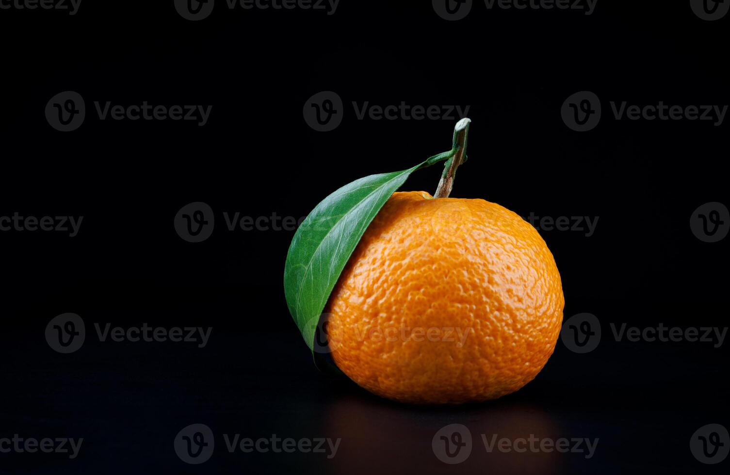 Ripe juicy tangerine on a dark background. photo