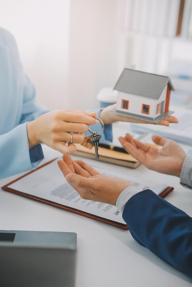 Real estate agent talked about the terms of the home purchase agreement and asked the customer to sign the documents to make the contract legally, Home sales and home insurance concept. photo