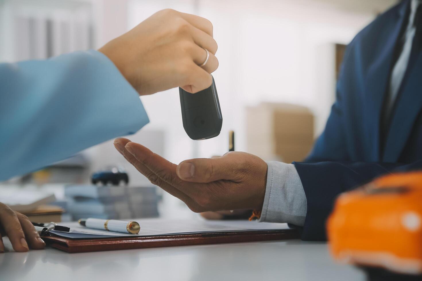 Insurance officers hand over the car keys after the tenant. have signed an auto insurance document or a lease or agreement document Buying or selling a new or used car with a car photo