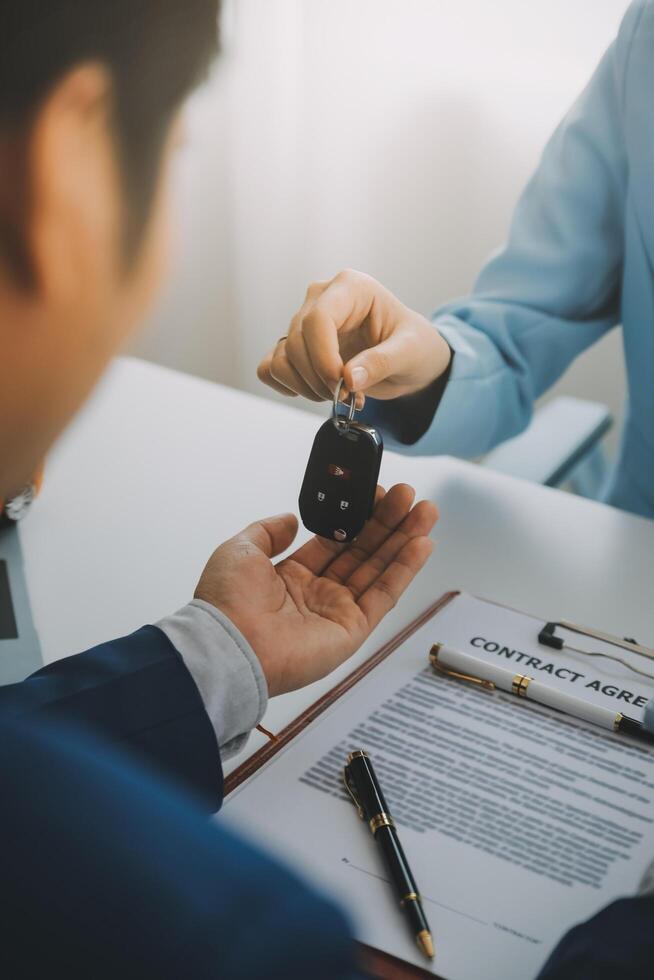 Insurance officers hand over the car keys after the tenant. have signed an auto insurance document or a lease or agreement document Buying or selling a new or used car with a car photo