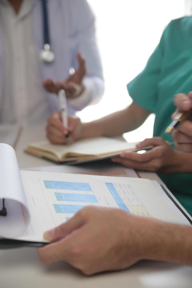 médico equipo reunión alrededor mesa en moderno hospital foto